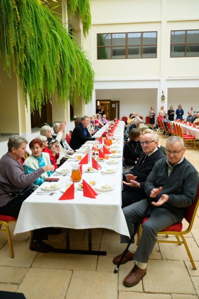 goście Kolacji Wigilinjnej siedzą przy zastawionym stole