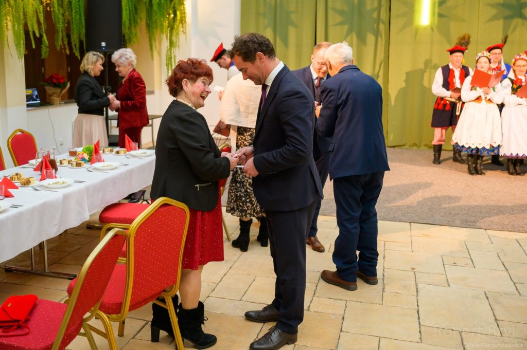 uczestnicy kolacji wigilijnej składają sobie życzenia