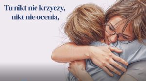 Rysunek kobiety tulącej dziecko i napis Tu nikt nie krzyczy nikt nie ocenia