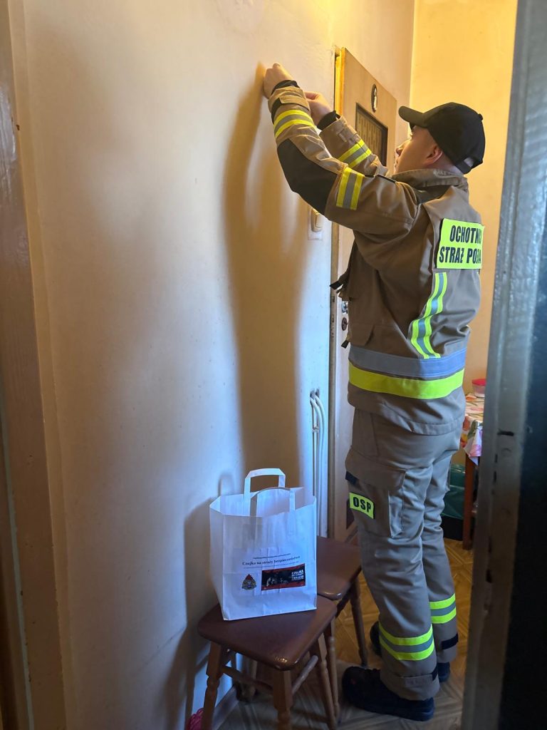 strażak montujący czujkę dymu