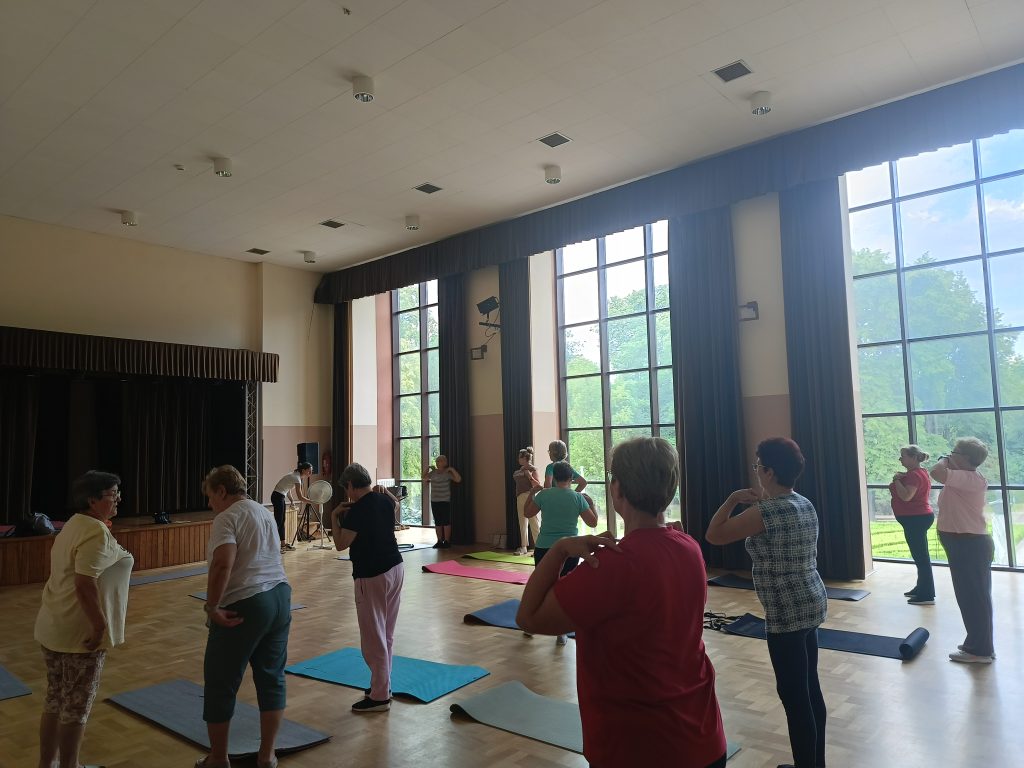 zdjęcie przedstawiające ćwiczące na sali osoby